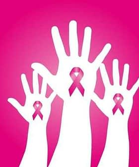 Three white hands raised with pink ribbons symbolizing breast cancer awareness. - Olive Oil Times