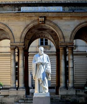 White statue of a historical figure located in the courtyard of the College de France building. - Olive Oil Times