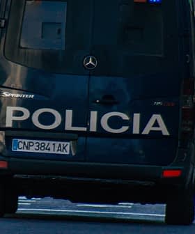 Rear view of a police van with the word 'Policia' on the back, driving on a city street. - Olive Oil Times