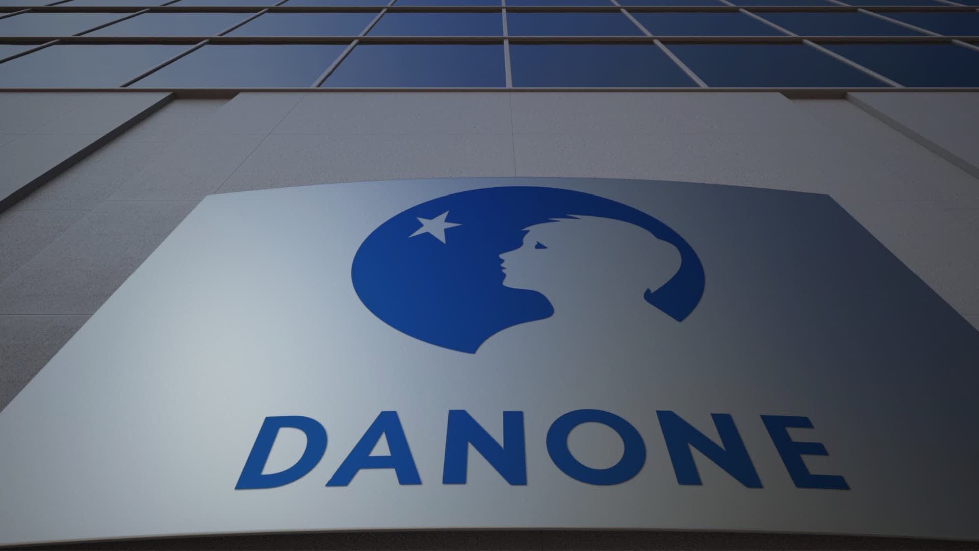 Danone company logo displayed on a building facade with a blue silhouette of a child's profile. - Olive Oil Times