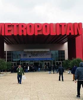 Entrance of the Metropolitan Exhibition Center with a large red sign above the doors. - Olive Oil Times