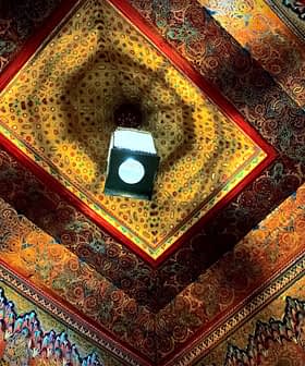 Intricate ceiling design featuring colorful patterns and a central light fixture. - Olive Oil Times