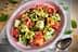 Bowl of fruit salad featuring watermelon, cantaloupe, cucumber, mint, and pistachios on a decorative plate. - Olive Oil Times